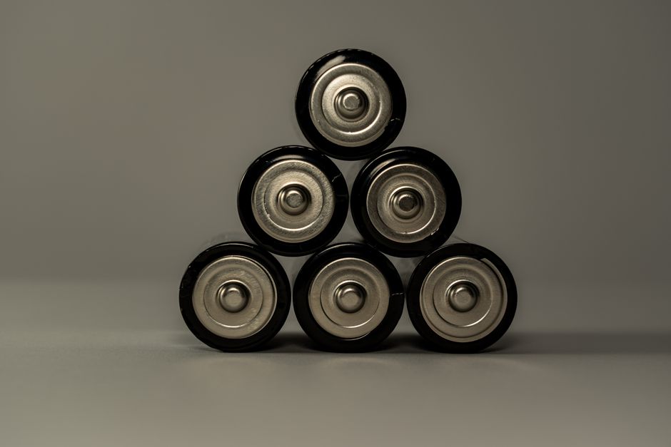 Een moderne thuisbatterij naast zonnepanelen op een zonnige dag, symboliserend duurzame energieoplossingen.
